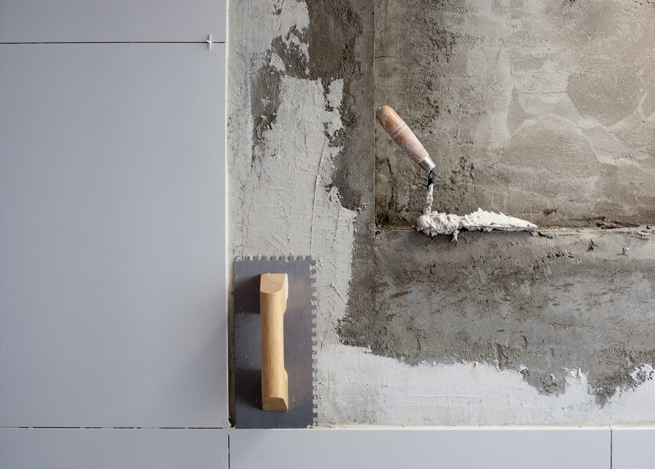 construction tools notched trowel on tiles mortar wall